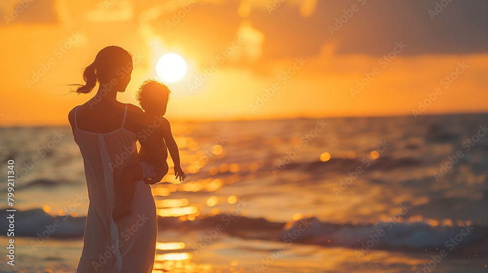 Woman Holding Baby on Beach at Sunset