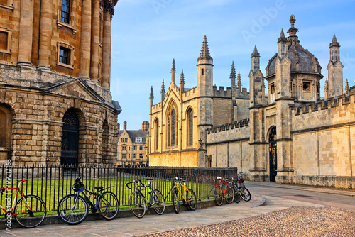 Oxford University at dusk, England, UK. Radcliffe Camera and All Souls College with bicycles on cobblestone streets.