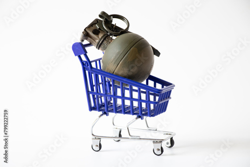 A hand grenade lies in a shopping cart on a white background, gun trade, gun store