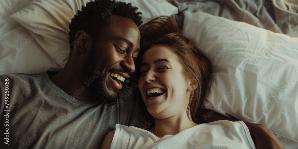 Happy woman relaxes in bed with man and enjoys romance at home. Couple, relationship, and morning laughter for honeymoon love, caring, and happiness