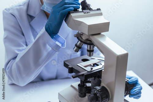 Hands of a doctor or female doctor collecting blood sample tubes from rack with analyzer in lab. Doctor holding blood test tube in research laboratory red blood cells