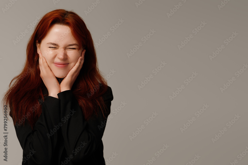Fototapeta premium Beauty with freckles smiling. Portrait of beautiful woman with redhair. Confident female wearing black blazer while posing at dark background