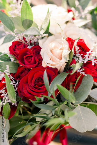 A close-up of a beautiful flower arrangement with green leaves  pink  and red roses. 