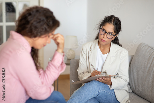 Women Therapist and Client Sitting on Couch Talking