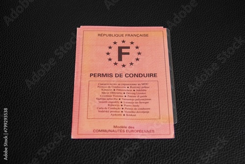 Un vieux permis de conduire Français en papier rose sur support noir 