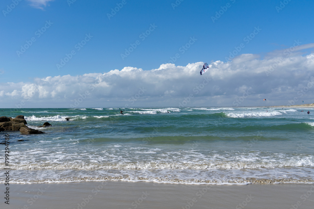 A la pointe de la Torche, dans le Finistère Sud, surfeurs et kitesurfeurs évoluent avec grâce dans les eaux de Bretagne, capturant l'essence dynamique de l'océan.