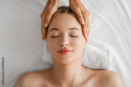 Serene Woman Enjoying a Relaxing Head Massage at a Spa