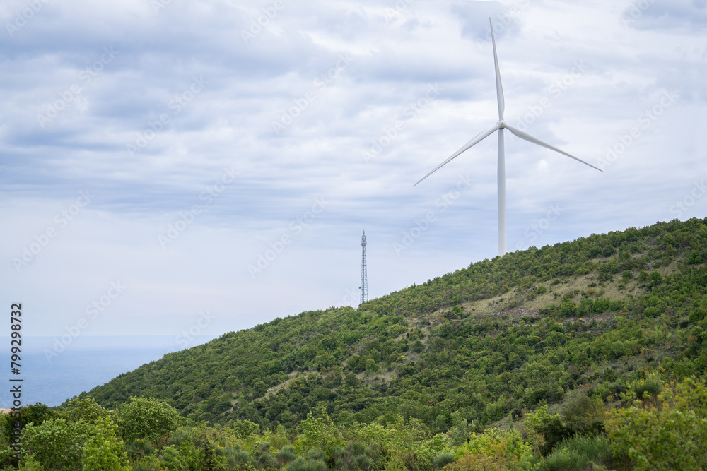 Wind turbine on the top of the mountatin with sea in background