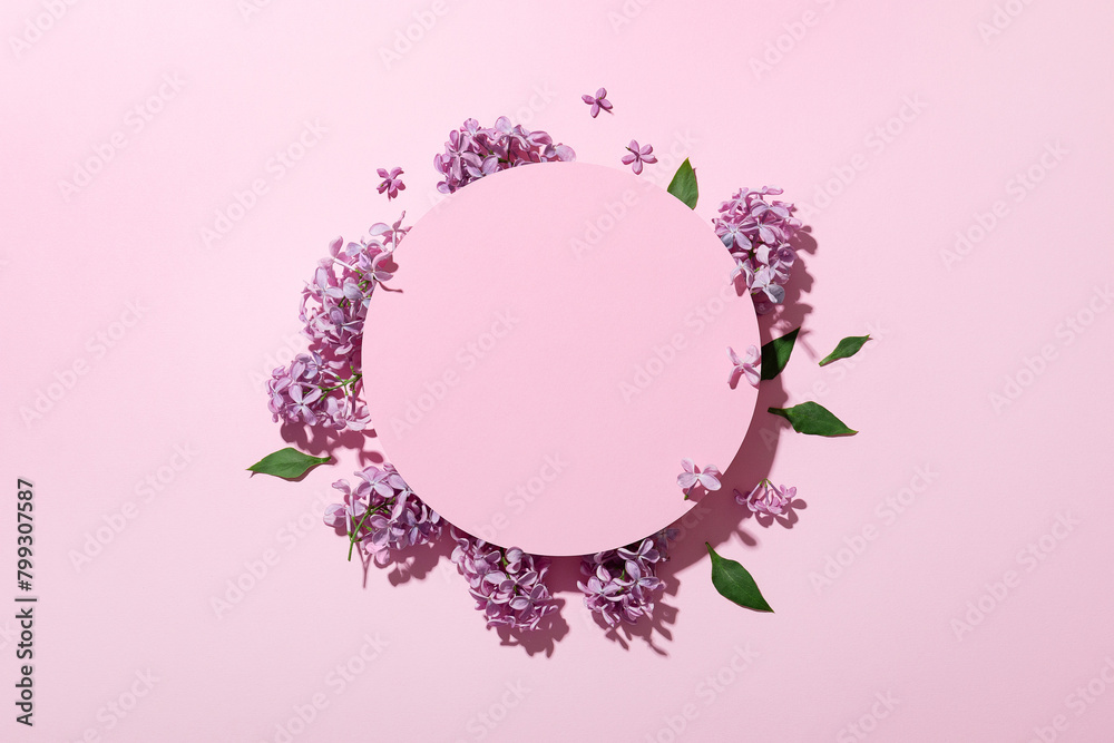Lilac on a pink background. Beautiful fresh flowers. Cosmetic circle podium and lilac on light pink background. Flat lay.Top view.
