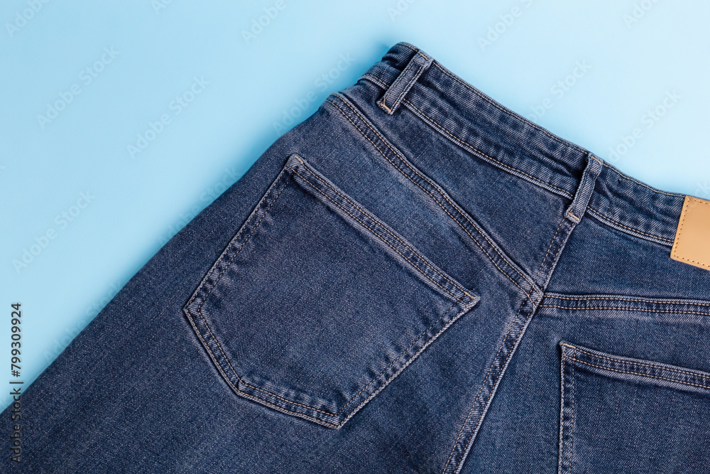 Blue jeans in the back from above on a blue background. Back pocket jeans. Top view. Denim cloth. Mockup