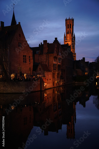 Night view of a canal in the Belgian town of Brugge with the Belfry of the townhall in the background 