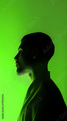 A man's silhouette against a neon green background, with soft lighting casting gentle shadows on his face and shoulders,Focusing on the upper body. Generative AI.