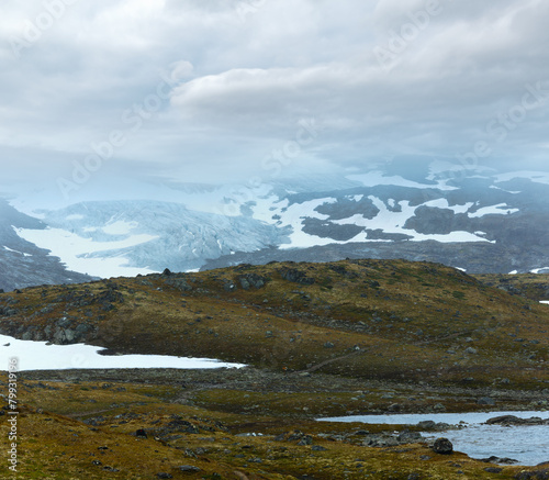 Dense fog and summer mountain landscape with lake and snow (Norway, not far Nigardsbreen glacier).