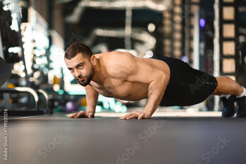 Handsome Millennial Shirtless Man Doing Push Ups in Gym