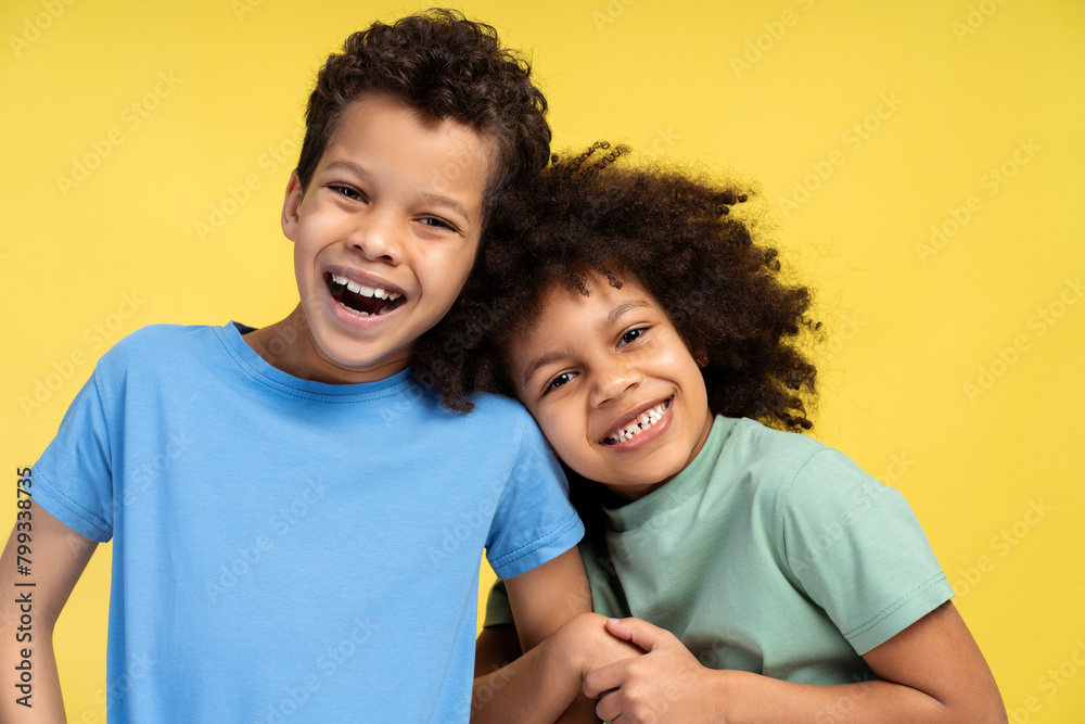 Little cite girl hugging boy while posing in studio, looking at camera. Friendship concept Little cite girl hugging boy while posing in studio, looking at camera. Friendship concept