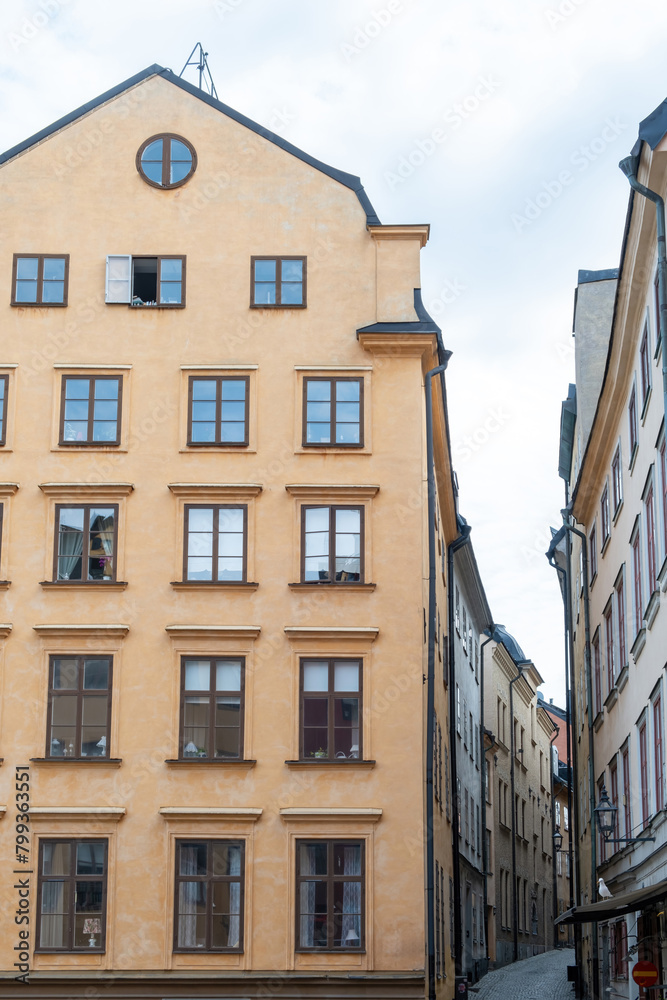 Sweden Stockholm, imposing building with big window narrow paved alley Gamla Stan Old Town. Vertical