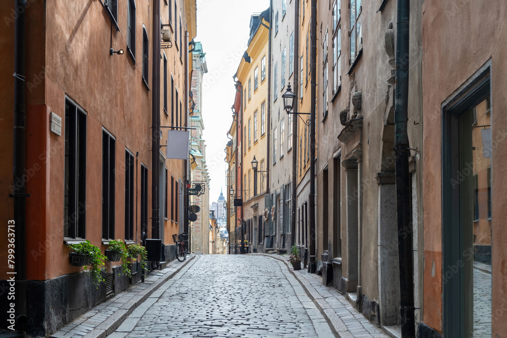 Stockholm Sweden Gamla Stan, traditional colorful building, narrow winding cobblestone alley.
