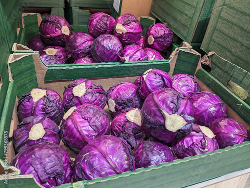 Box filled with purple cabbages for sale on market