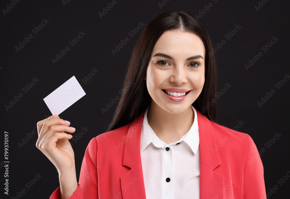 Happy woman holding blank business card on black background Happy woman holding blank business card on black background