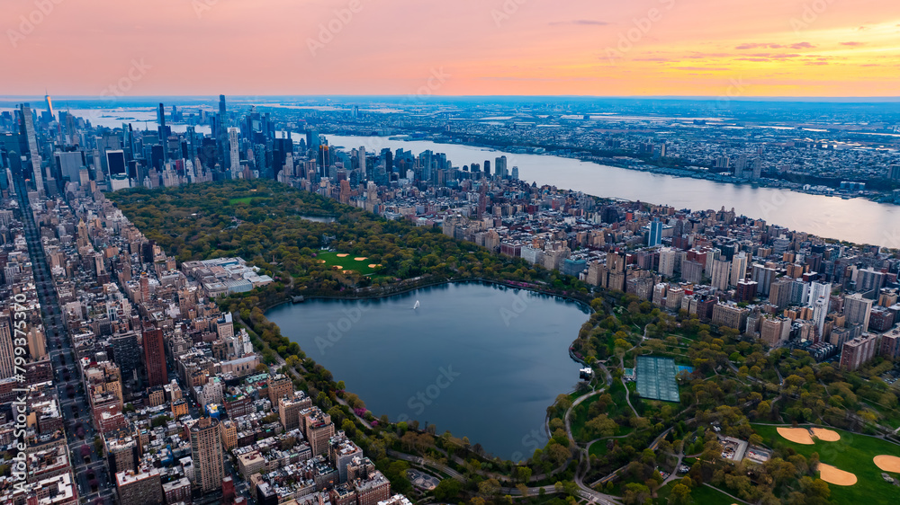 Fototapeta premium Scenic view of Central Park in the cityscape of New York, the USA. Aerial perspective. Enormous city panorama at sunset.