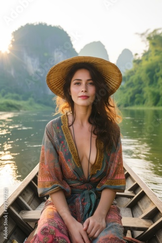 beautiful woman in straw hat relaxing in boat on river with green mountain background © Adobe Contributor