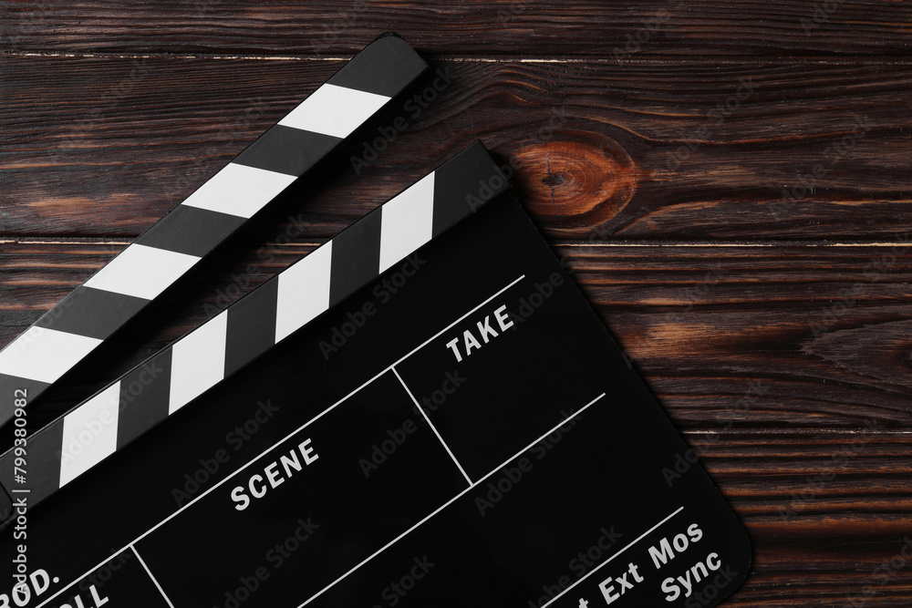 Clapperboard on wooden table, top view. Space for text