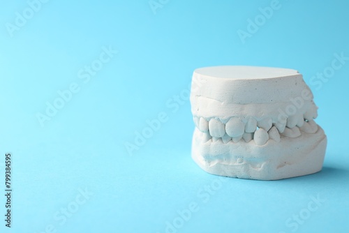 Dental model with gums on light blue background, space for text. Cast of teeth photo