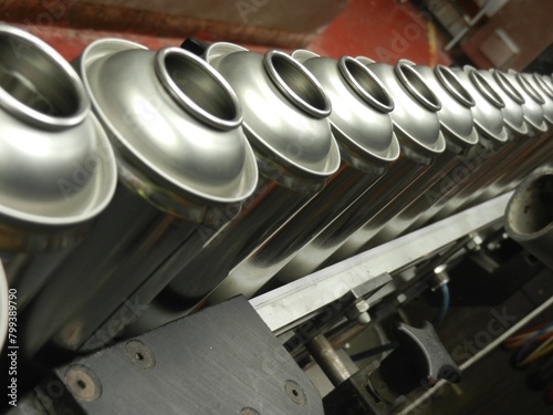 Aerosol cans on production filling line in busy factory