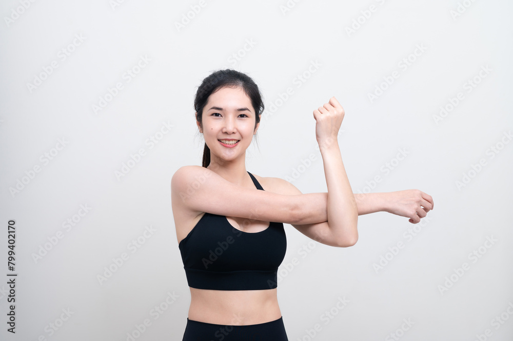 Attractive Asian woman in black workout clothes doing arm stretching on white background. Confident young female athlete body warm up before workout on isolated. Attractive Asian woman in black workout clothes doing arm stretching on white background. Confident young female athlete body warm up before workout on isolated.