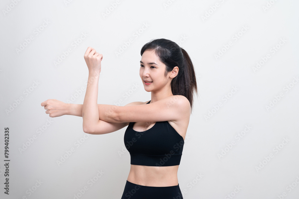 Attractive Asian woman in black workout clothes doing arm stretching on white background. Confident young female athlete body warm up before workout on isolated. Attractive Asian woman in black workout clothes doing arm stretching on white background. Confident young female athlete body warm up before workout on isolated.