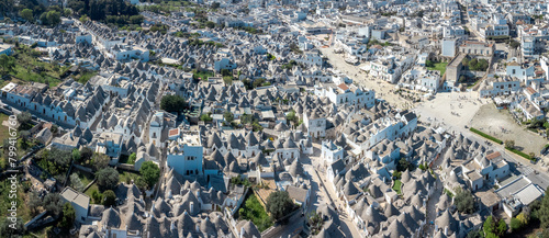  Aerial drone view of Beautiful stone Trulli houses with narrow streets in village of Alberobello. Picturesque village on a hill in Apulia, southern italy. 