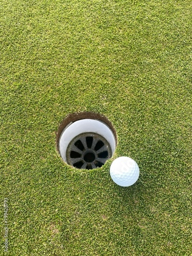 golf ball next to hole