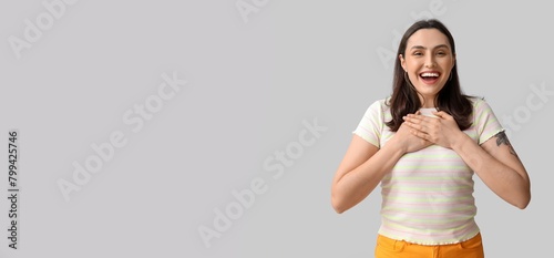 Smiling young woman on grey...