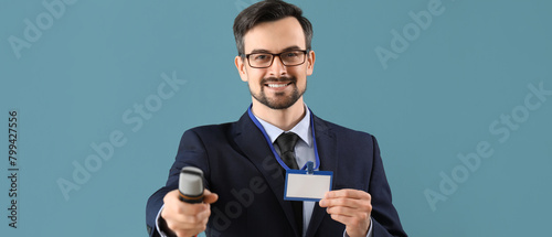 Male journalist with badge and microphone on blue background