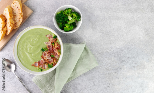 Creamy broccoli soup with bacon and croutons on a gray background. Top view. Copy space.