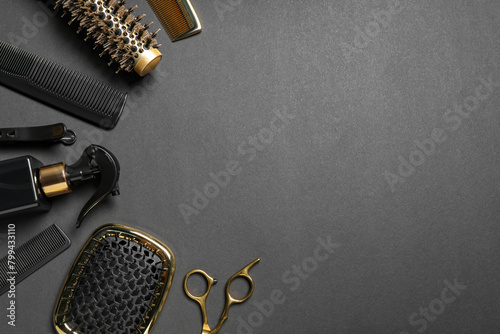 Hairdressing tools on dark table, flat lay. Space for text