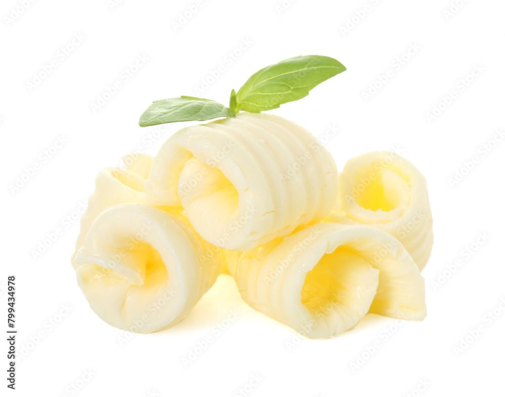 Pile of tasty butter curls and basil leaves isolated on white Pile of tasty butter curls and basil leaves isolated on white