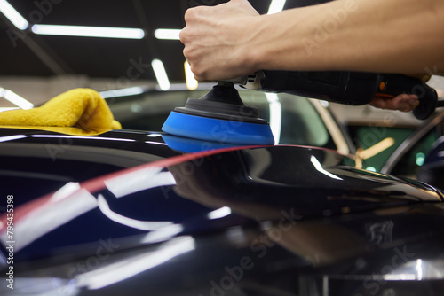 Person using machine to polish black cars automotive exterior © Евгений Вершинин