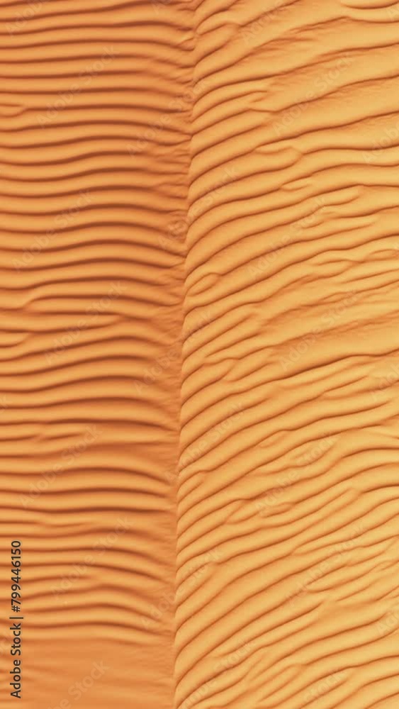 Vertical video. Detailed view of a desert sand dune, showcasing the textured surface and intricate patterns formed by winds. The light and shadow play highlight the curves and ridges of the dune,. Vertical video. Detailed view of a desert sand dune, showcasing the textured surface and intricate patterns formed by winds. The light and shadow play highlight the curves and ridges of the dune,.