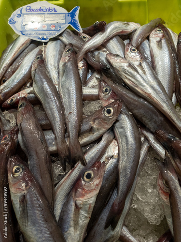 many young cod fishes (gadus) offered in a plastic box on a fish market