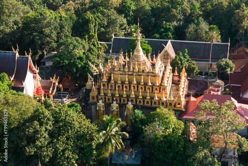 Top view of golden pagoda and church at Wat Phra That Suthon Mongkhon Khiri Samakkhitham. It is a prominent temple in the most beautiful collection of applied art. Located at Phae Province in Thailand photo
