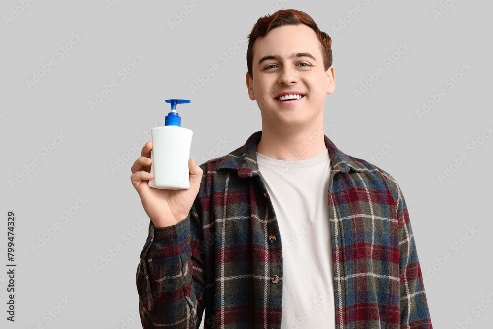 Young man with sanitizer on light background Young man with sanitizer on light background