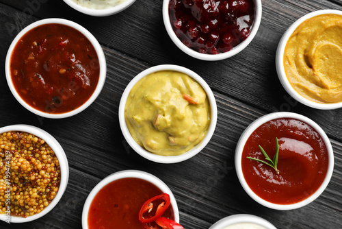 Wallpaper Mural Different tasty sauces in bowls on black wooden table, flat lay Torontodigital.ca