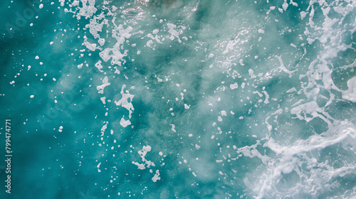 Aerial view of turquoise ocean waters with a textured overlay of white sea foam creating a dynamic and natural abstract surface perfect for backgrounds and aquatic-themed projects