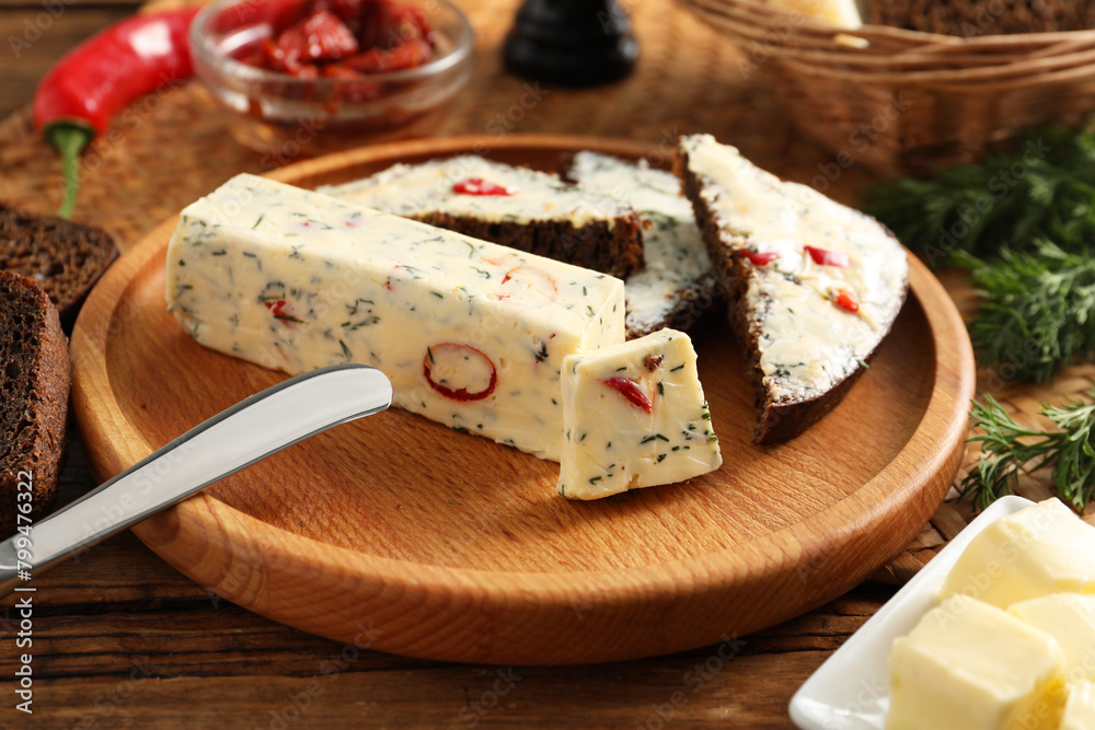 Tasty butter with dill, chili pepper and rye bread on wooden table Tasty butter with dill, chili pepper and rye bread on wooden table