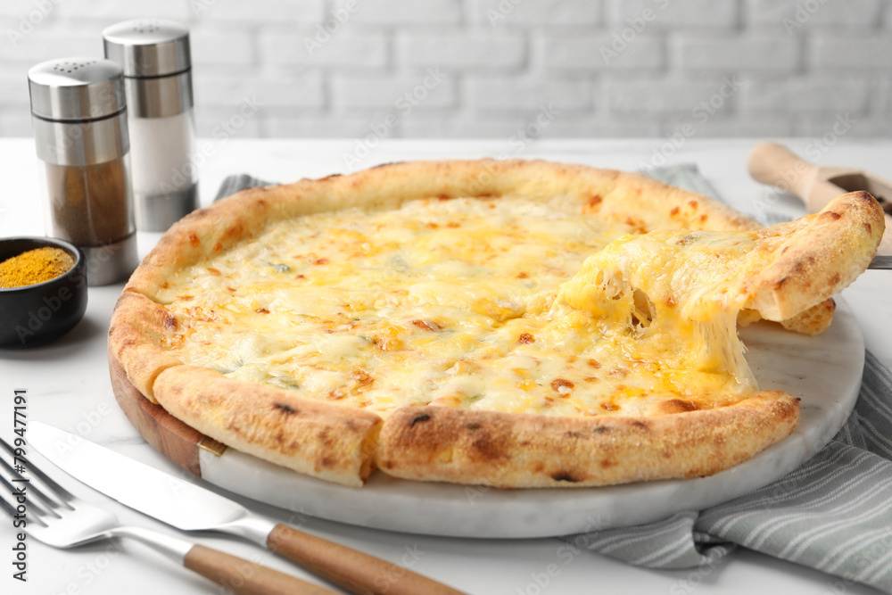 Taking piece of delicious cheese pizza at white table, closeup Taking piece of delicious cheese pizza at white table, closeup