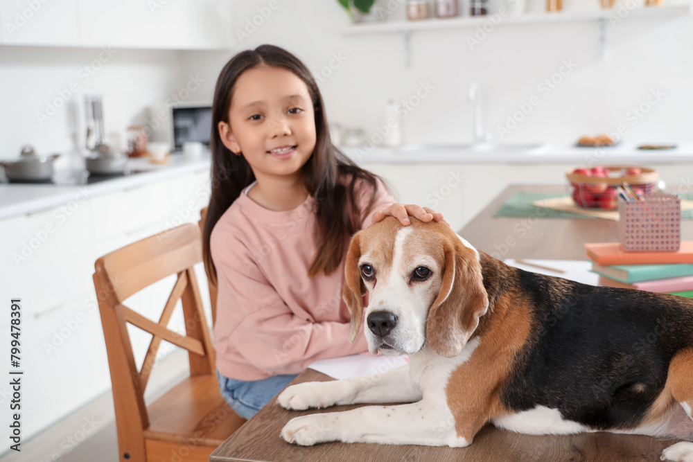 Cute Beagle dog with little girl drawing on table in kitchen, closeup Cute Beagle dog with little girl drawing on table in kitchen, closeup