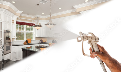 Professional Spray Painter Holding Spray Gun Spraying New Renovated Kitchen Over White Surface. photo