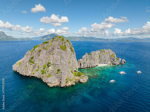 Tourist boats over the blue sea in Twin Rocks. Blue sky and clouds. El Nido, Palawan. Philippines.