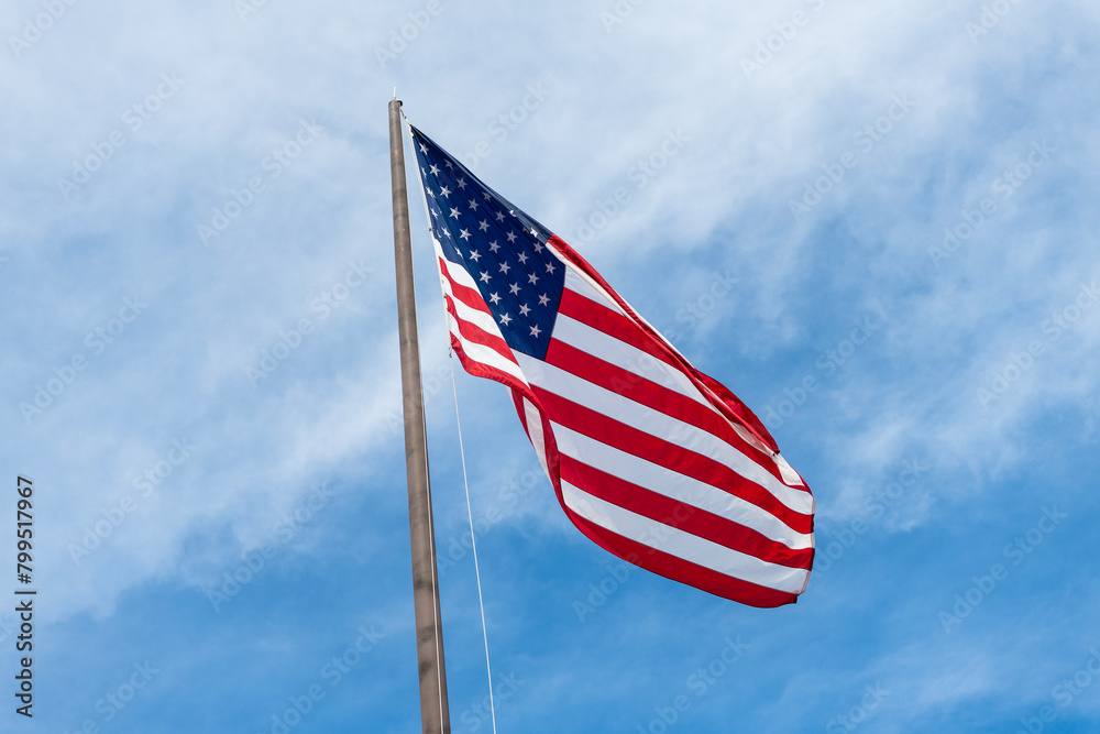 American Flag for Memorial Day or 4th of July. American flag waving in the wind. Flag of the USA. National waving flag of united states on blue sky. Independence day. Patriotic symbol